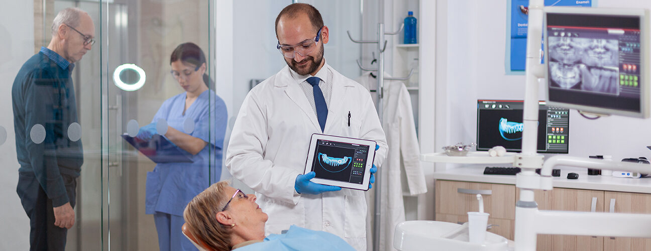 dentist holding tab and showing digital scan to patient